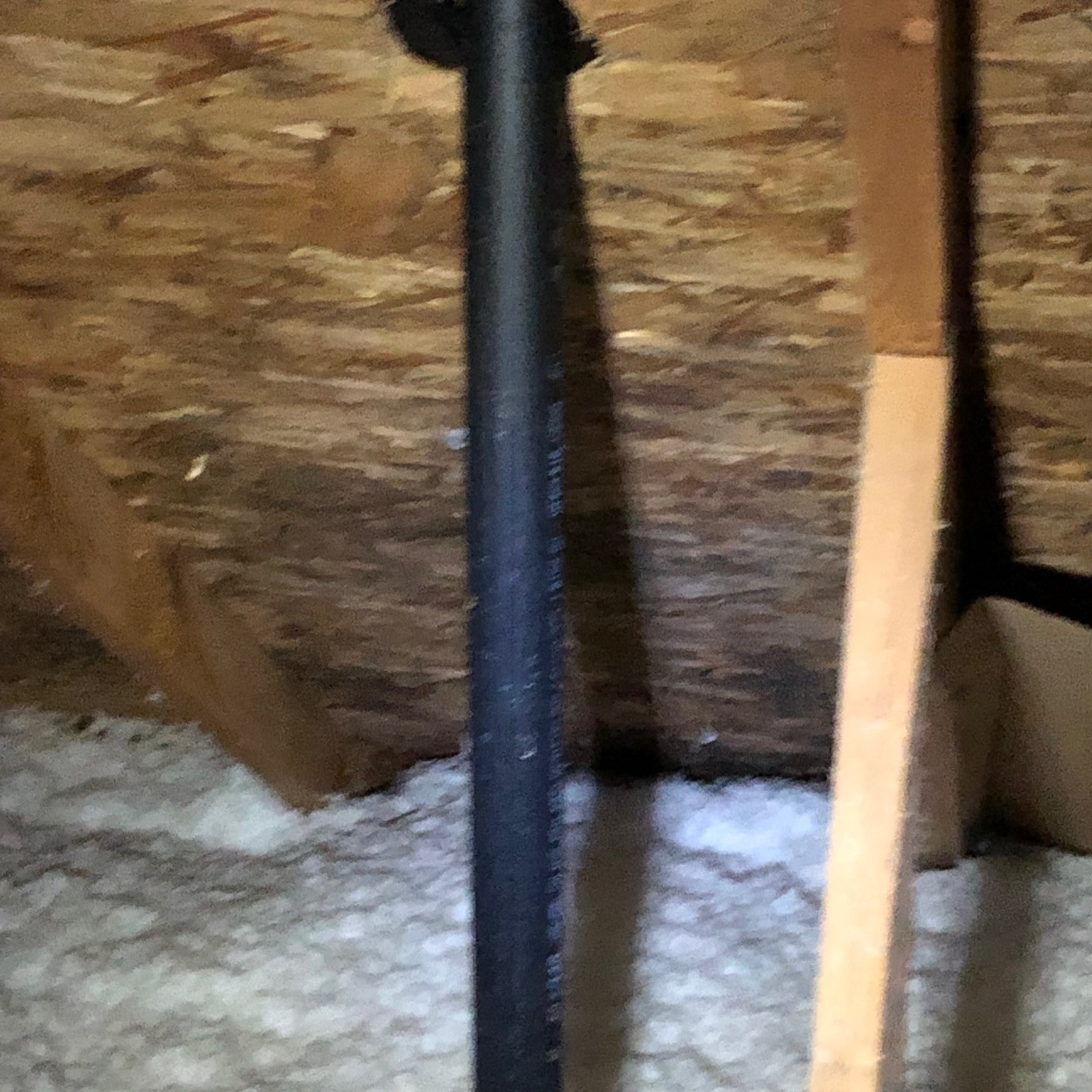 Tex Roof technician tracing a roof leak in an Austin attic with a flashlight