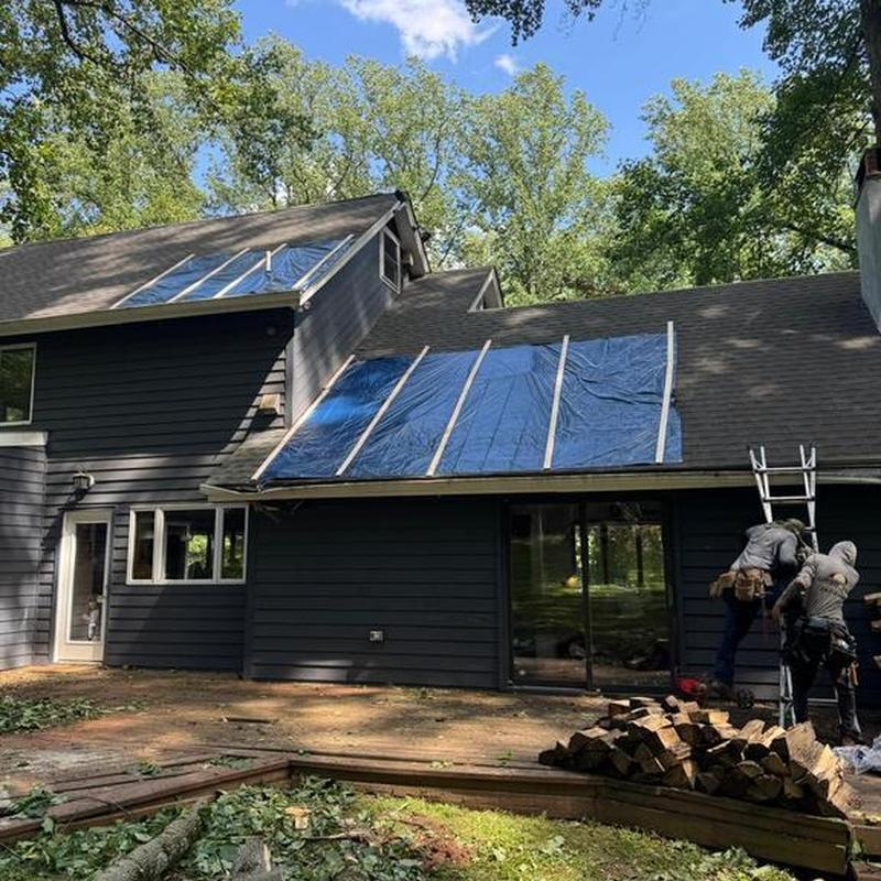 Emergency tarp secured with wood battens on an Austin home after wind damage